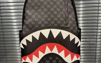 A backpack printed with a jagged band of white shark teeth across the front panel, shot against a shutter