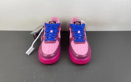 A pair of pink and blue high-top trainers standing side by side on a grey surface